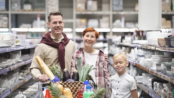 Portrait of Happy Young Family Shopping for Groceries in Supermarket Together with Little Boy