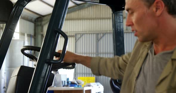Portrait of happy worker standing near forklift 4k alt