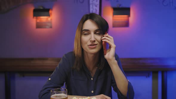 Portrait of Young Woman Making Mobile Phone Call in Pub