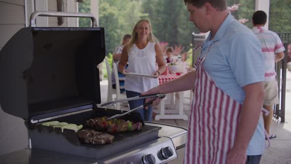 Serving food from grill at backyard barbeque