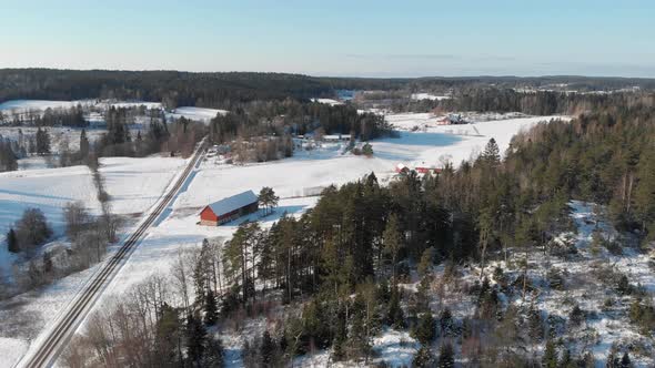 Traditional Barn and Farmland in Sweden During Winter Aerial Establishing