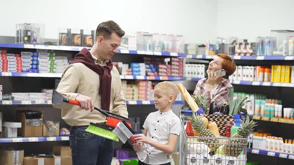 Family in the Supermarket Chooses a Brush for the Car