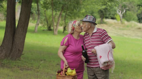 Family Weekend Picnic. Active Senior Old Caucasian Couple in Park. Husband and Wife Walk Together alt