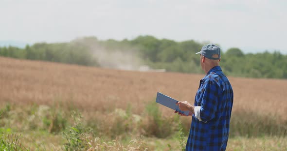 Mature Male Farmer Writing On Clipboard At Farm alt