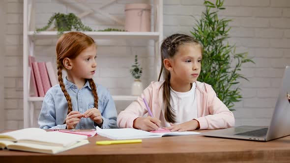 Two Little Children Girl Have Video Call with Teacher Using Laptop for Studying Online