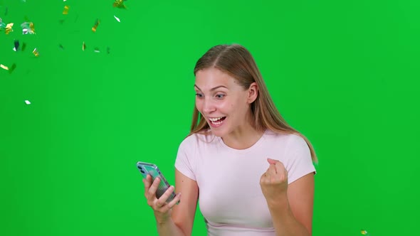 Female Uses a Smartphone Looks at the Screen and Learns About the Win Young Woman Wins Golden alt
