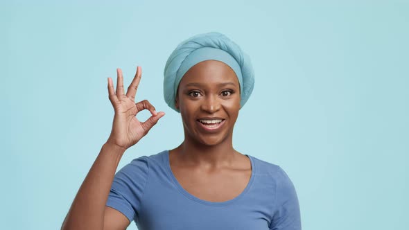 African American Lady Gesturing And Saying OK Over Blue Background alt