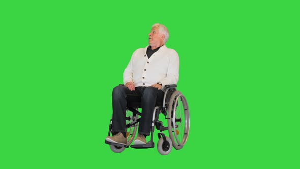 Old Man Sitting Alone in a Wheelchair and Waiting on a Green Screen, Chroma Key. alt