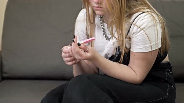 Teenage Girl Looks Fearfully at a Pregnancy Test