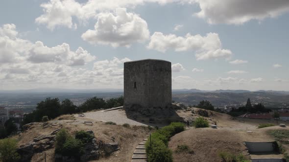 Aerial orbiting view Medieval Castle of Guarda, old stone tower on hilltop, Portugal