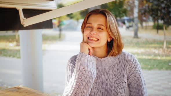Young Happy Hipster Student in Sitting at Street Cafe Alone Enjoying Weekend alt