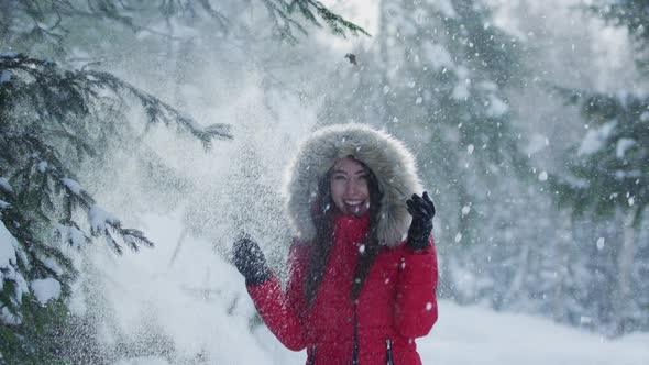 Girl standing under falling snow alt