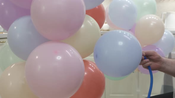 Man Blowing Up Balloons to Decorate Home for Party Balloon Festive Stand with Colorful Balloons for alt