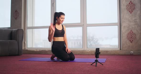 Pretty Slim Girl Trainer Blogger Doing Yoga Showing Video Class Via Smartphone alt