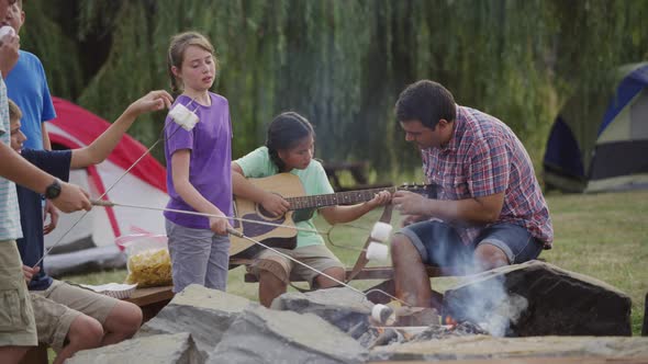 Kids at summer camp around campfire