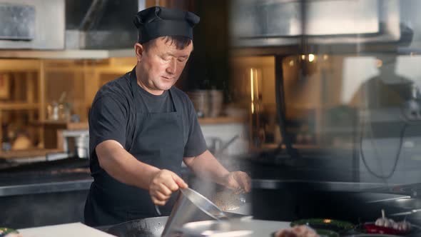 Asian Male Chef Cooking Food at Frying Pan Filling Water at Cuisine alt