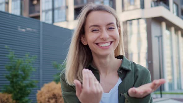 Beautiful Blonde Girl Turns to the Camera and Hand Gesture Calls Follow Me alt