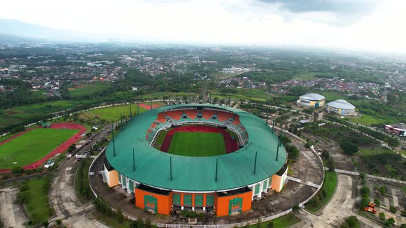 Aerial View of The largest stadium of Pakansari Bogor from drone and noise cloud. alt