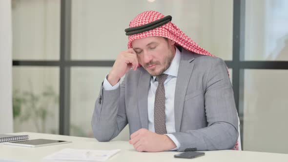 Sleepy Middle Aged Arab Businessman Taking Nap While Sitting in Office alt
