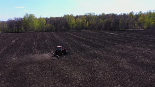 Tractor Plows the Field in Spring