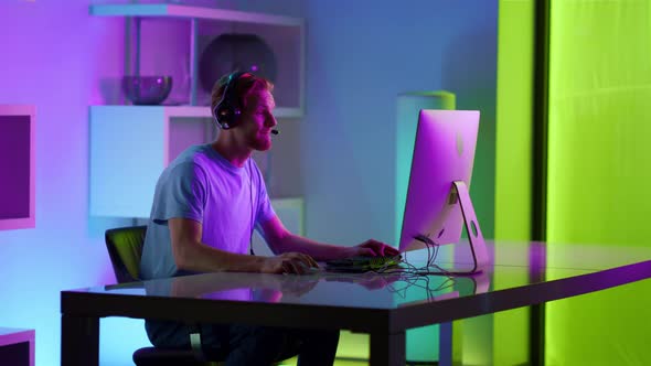 Excited Man Celebrating Gaming Tournament Victory in Neon Cyberspace at Home alt