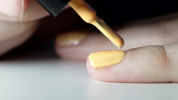 Girl Does a Manicure on Nails, Applies Orange Nail Polish, Beauty Salon, Macro alt