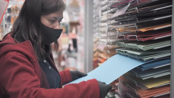 Lady in Mask and Gloves Buys Colored Paper in Shop