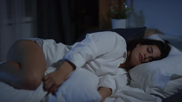 Pretty Woman Sleeping with Pillow between Knees at Night alt