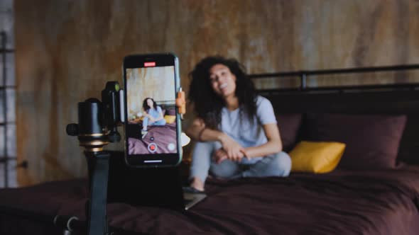 Portrait of Young African American Woman Blogger Streaming Live Using Smartphone Talking to alt