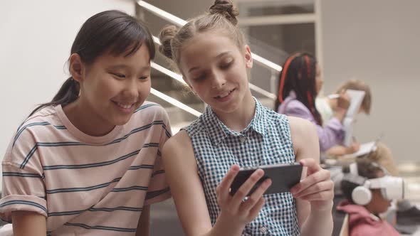 School Girls Watching Video on Smartphone at School, Stock Footage