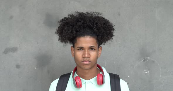 African American Teen Student Boy with Headphones and Afro Hair Looking at Camera