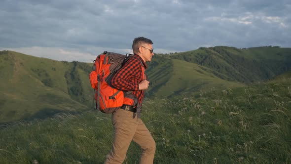 Tourist, a man with a backpack climbs the mountain, a journey through the mountains