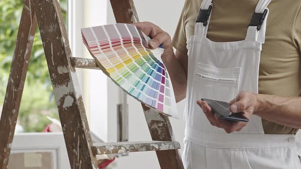 hands of house painter man decorator choose the color using the sample swatch