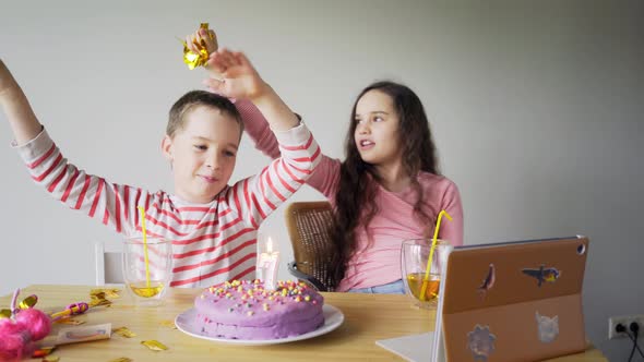 Boy Sings and Girl Pours Confetti Near Birthday Cake in Room