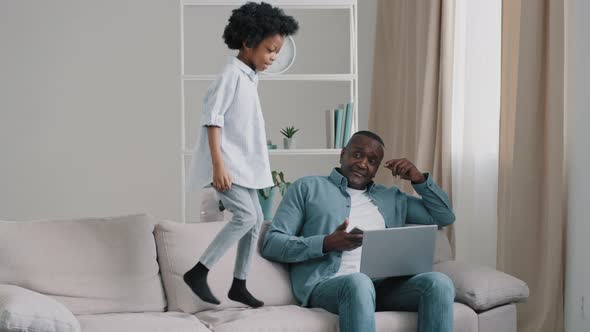 Little Girl Jumping on Sofa Disgruntled Man Angry By Child's Bad Behavior Daughter Interferes with alt