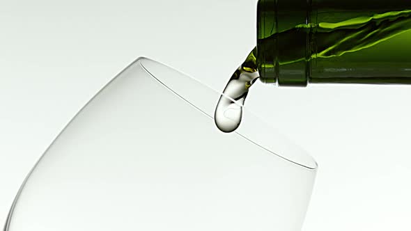 White Wine being poured into Glass, against White Background, Slow motion