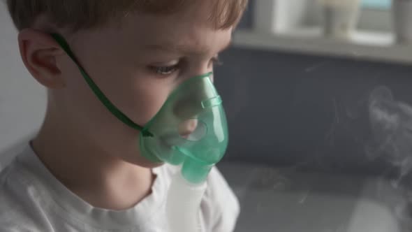 The Boy Make Inhalation Inhales the Medicine Through the Mask Nebulizer Mask