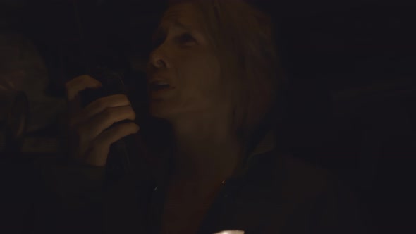 Woman with Flashlight in Dark Shelter Talking on Walkie-talkie alt