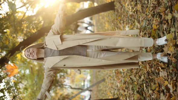 Happy Woman Throwing Leaves in Autumn in Slow Motion Smiling Full Length alt