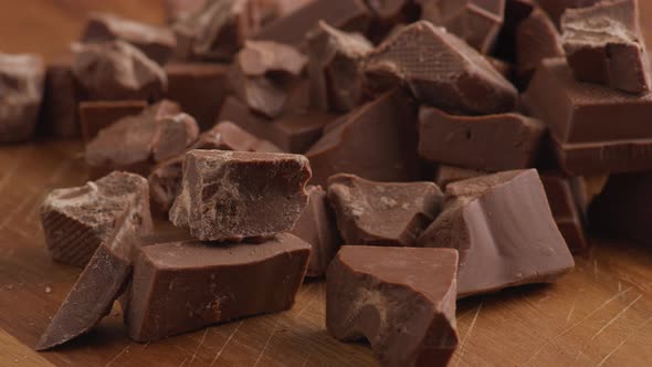 Chunks of chocolate on wooden surface