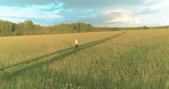 Sporty Child Runs Through a Green Wheat Field alt