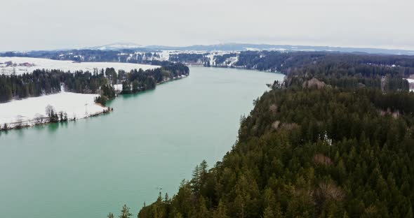 A View of a Wide River Flowing Among Spruce Forests and Snowcovered Fields alt