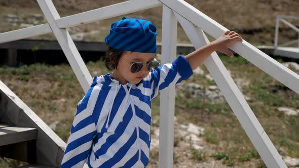 Boy Child in a Striped Blue Jacket and Bandana Walks alt