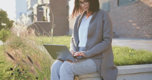 Woman Learning or Working Online Using Laptop Computer, Taking Notes, Studying Outdoor alt