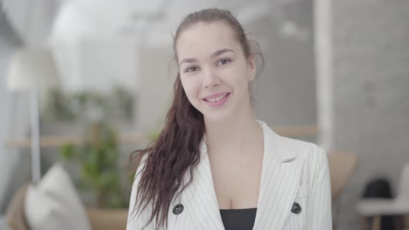 Portrait Cute Businesswoman Standing in a Light Comfortable Office Looking at the Camera alt