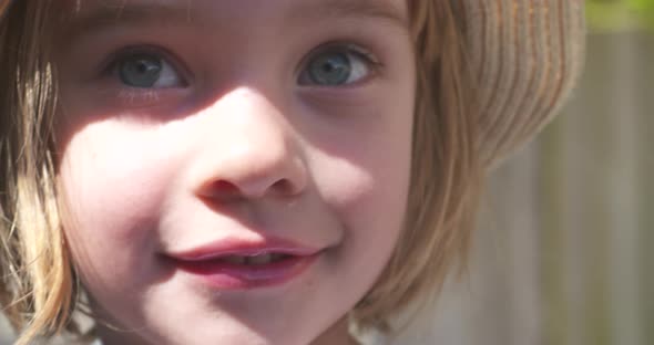 Close up portrait of a beautiful little girl smiling in the sunlight alt