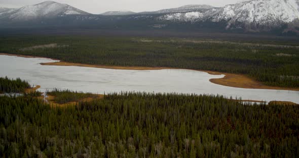 Aerial helicopter flyover of bridge over Alaskan river, extreme closeup on one person looking over t