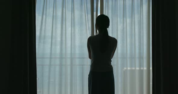 Woman open curtain at the morning alt