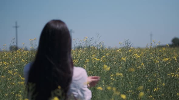 Pretty young woman in the rapeseed field