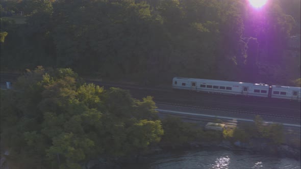 Aerial Drone Shot Tracking Train Leaving New York City Along Hudson River alt